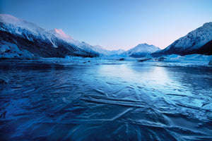 Frozen Tasman Lake with mountains at sunrise